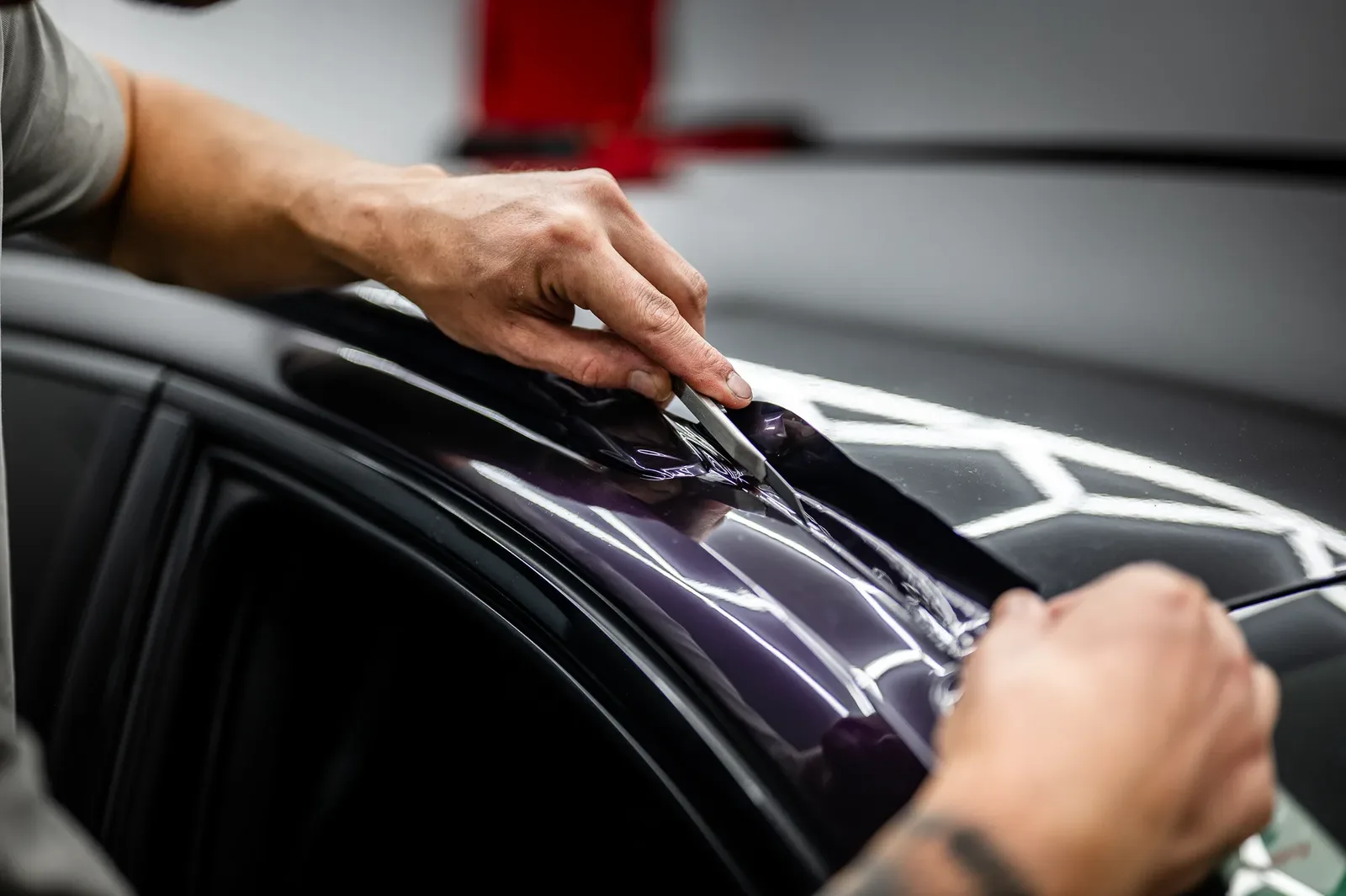 Purple colour PPF being installed over the roof of a car in the Christchurch workshop