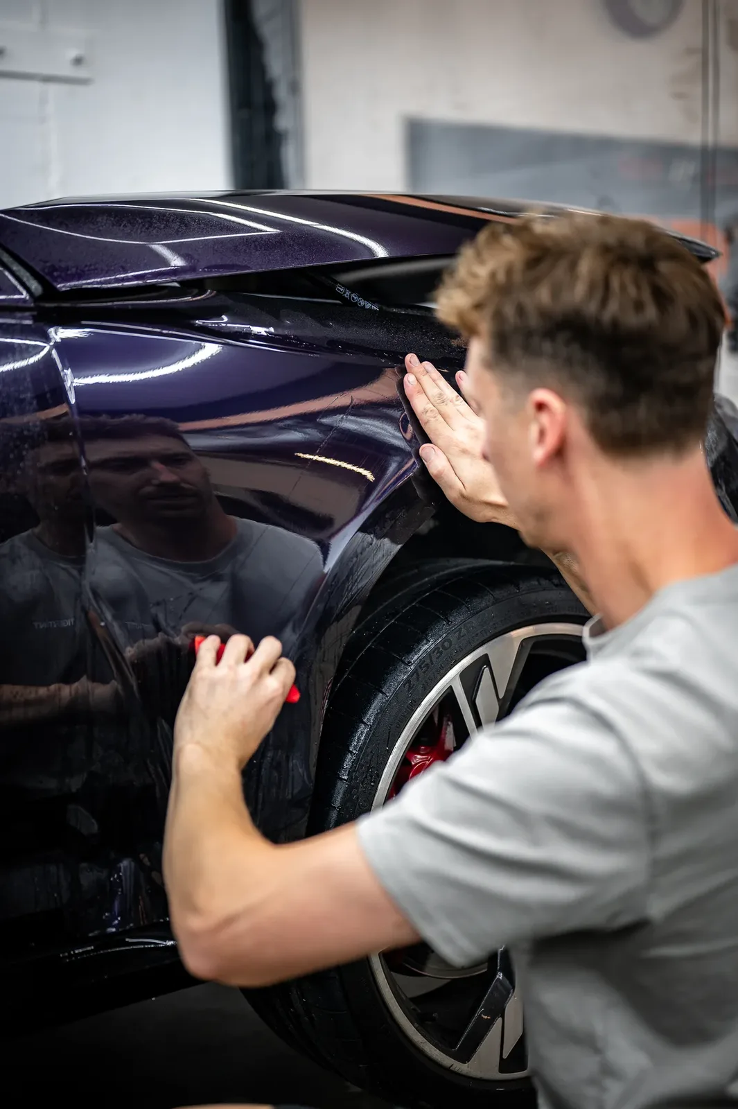 Paint protection film being wrapped around the front fender of an Audi in Christchurch