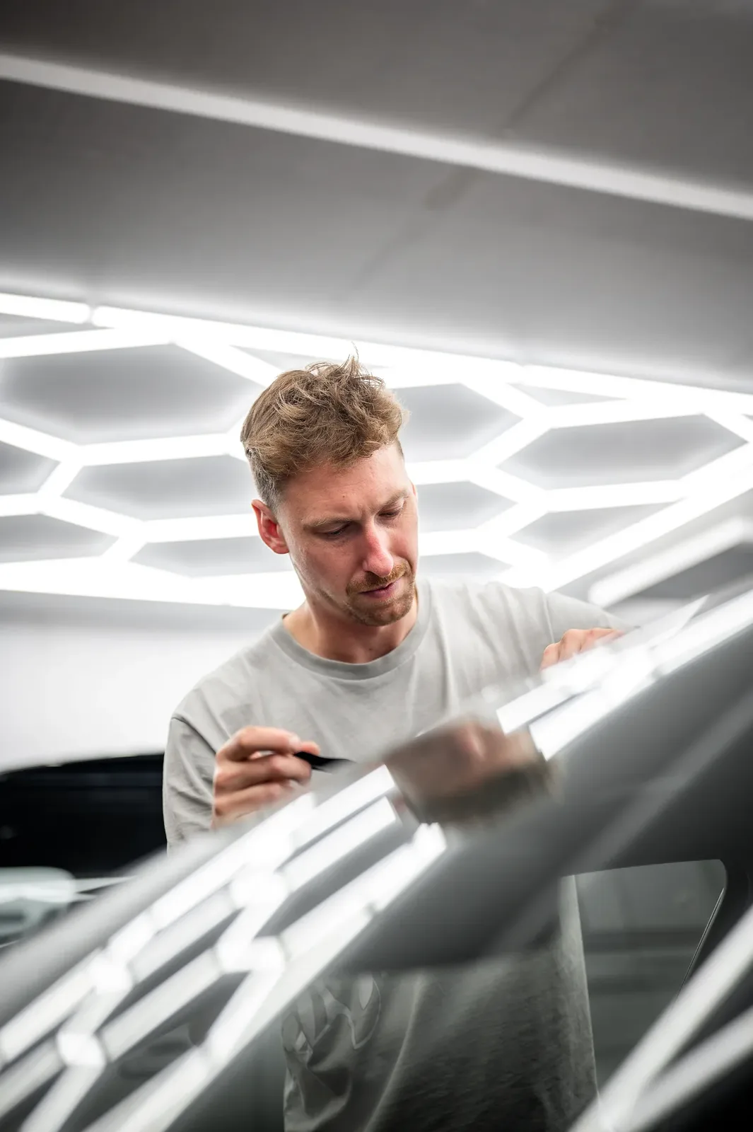 Paint protection film being installed on a car panel in the Tiger Tint & Wrap workshop