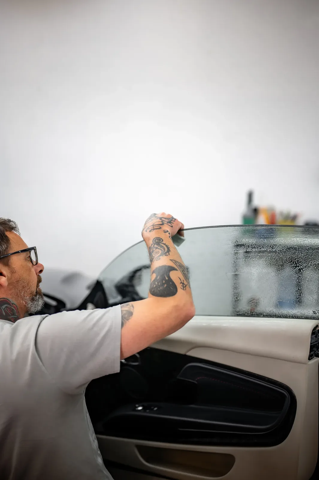Shaping tint film to a curved rear window during a window tinting job in Christchurch