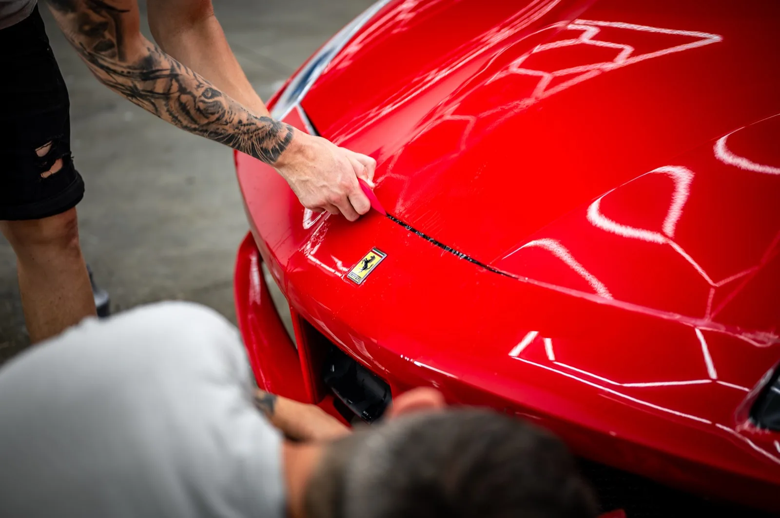 Brock installing paint protection film on a red Ferrari